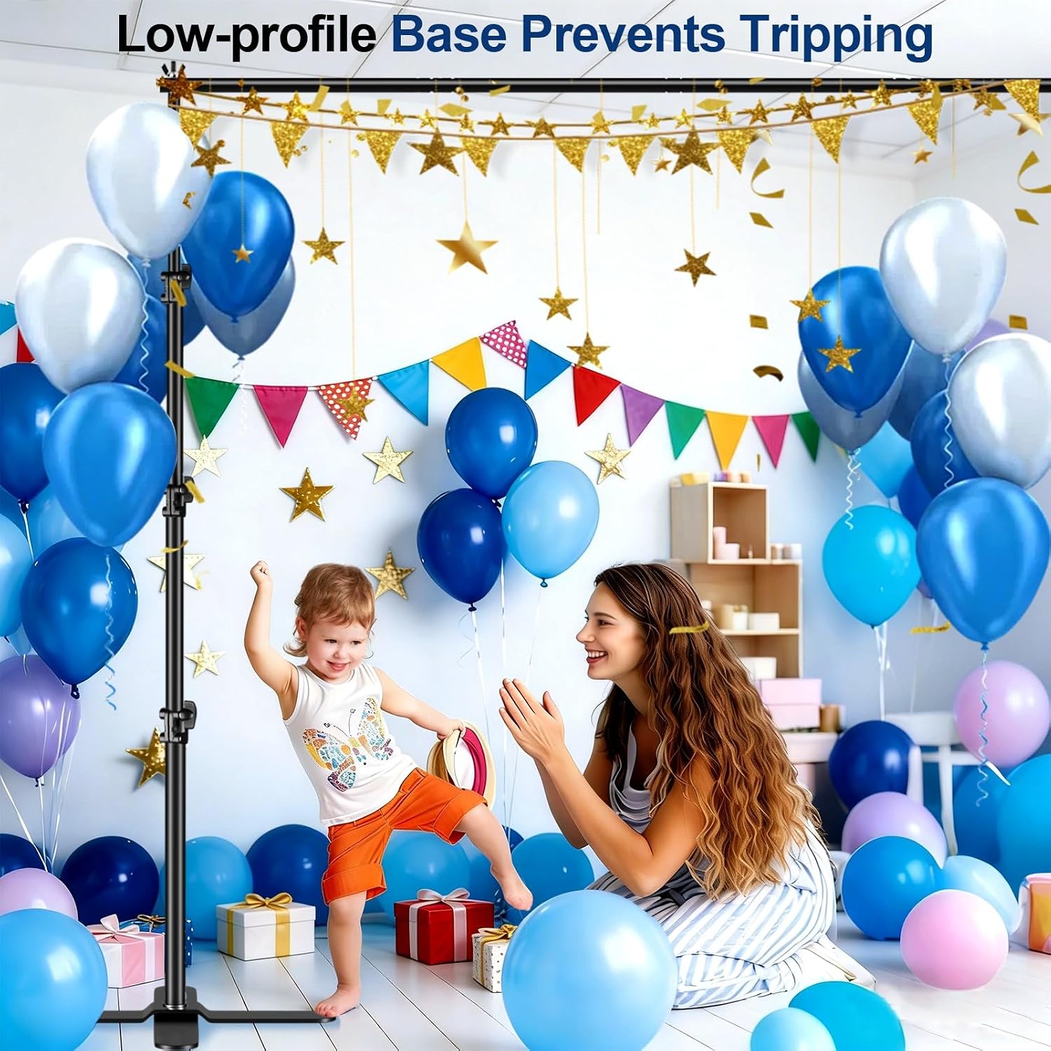 Mother and child at a blue balloon birthday setup framed by a backdrop stand with low-profile X-shaped bases.